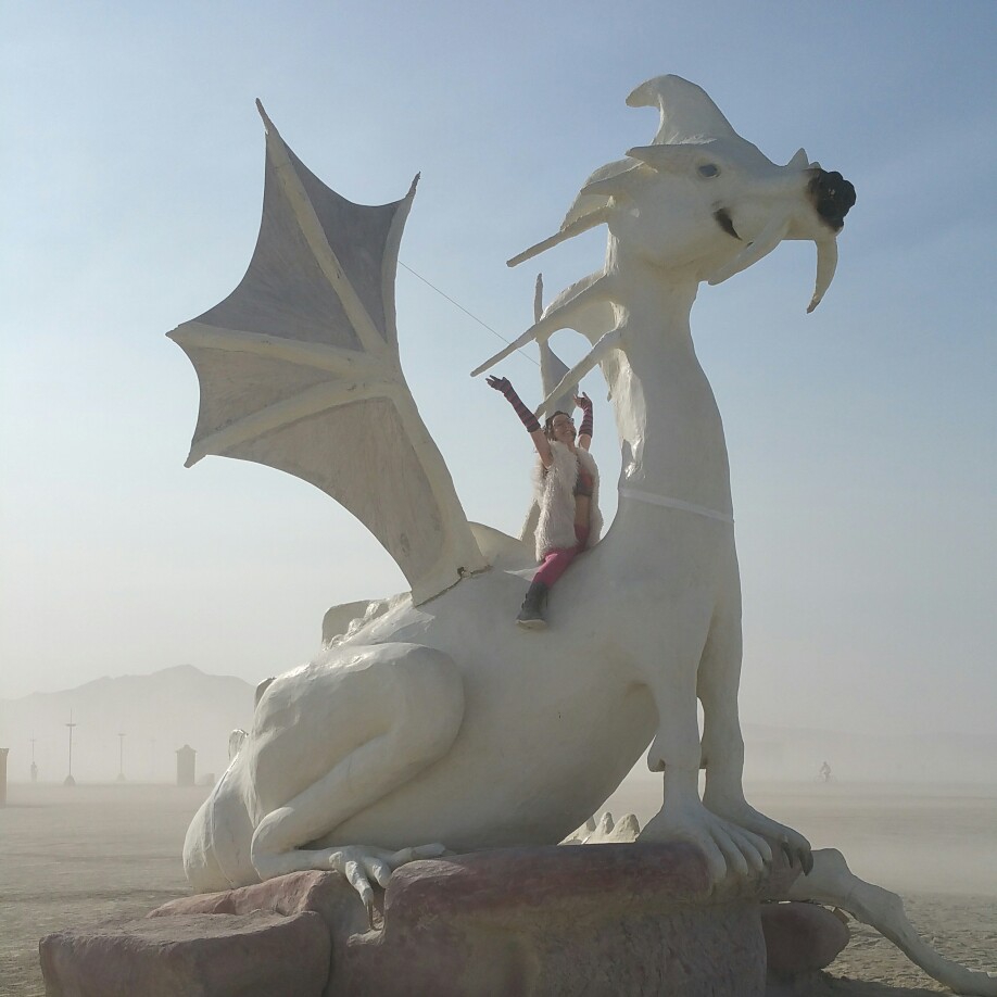 A woman sitting on a large white dragon statue